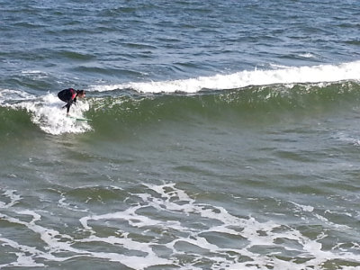 A surfer (in mid-February) as seen from the fishing pier on the East Coast of Tybee Island