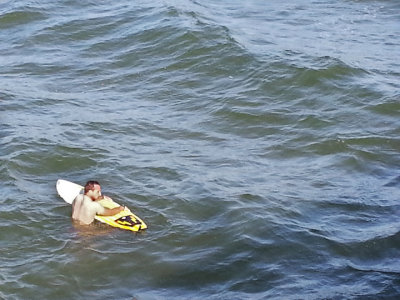 A surfer without a wetsuit (in mid-February) as seen from the fishing pier on the East Coast of Tybee Island