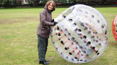 Judy deciding if she wants to try on a Battle Ball for a Bubble Soccer game - Forsyth Park in Savannah