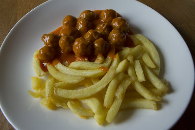 Frietjes met balletjes in tomatensaus