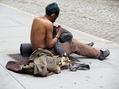 Homeless Man on a Sidewalk Heat Ventilator