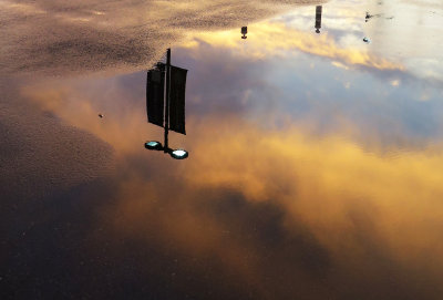 Sunset Sky Reflection in Parking Lot Rain Puddle