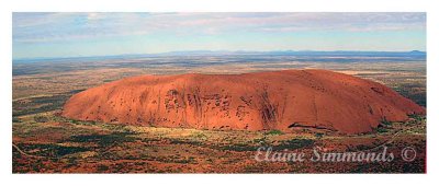This photograph was taken from
the air on a helicopter trip
around Uluru.  If you look in 
the distance you will see the distant
ranges. 
I was truly lucky the light was spectacular.