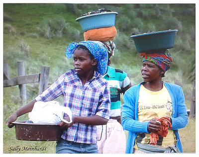 A common sight in Africa.
A woman will habitually carry things on her head.
This is strange to outsiders but so frequently seen in SA that one doesn't give it a second glance.
lnterestingly they are wearing Western clothes, 
but the woman on the right 
has a political message in English, on her blouse.... 
ANC LIVES    ANC LEADS
Referring to the political party, the 
African National Congress.  