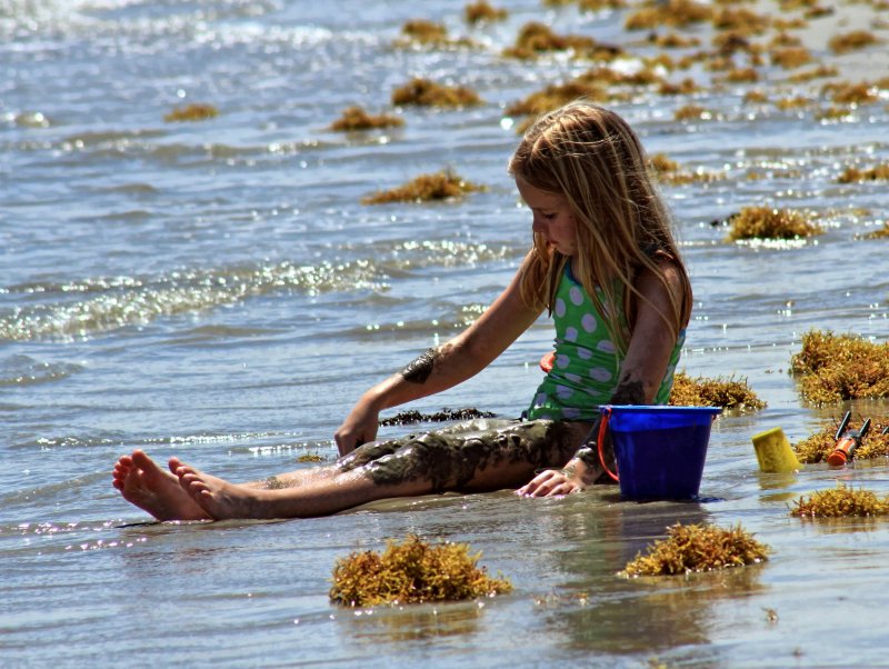 LITTLE GIRL PLAYING IN THE SAND