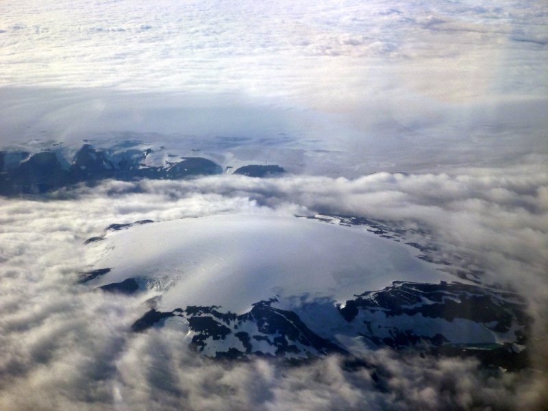 Looking down at volcanic craters peeking through the clouds