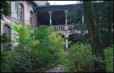 Men pavilion disappearing behind vegetation...