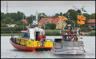 Rescue Boat Vringen towing a fishing boat in to Grnhgen harbor (land)