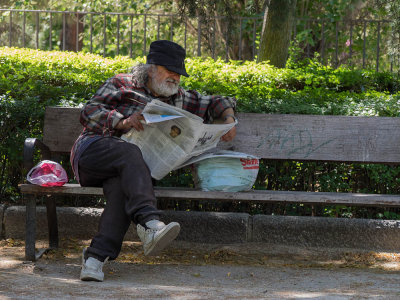 Reading newspaper in a cool park