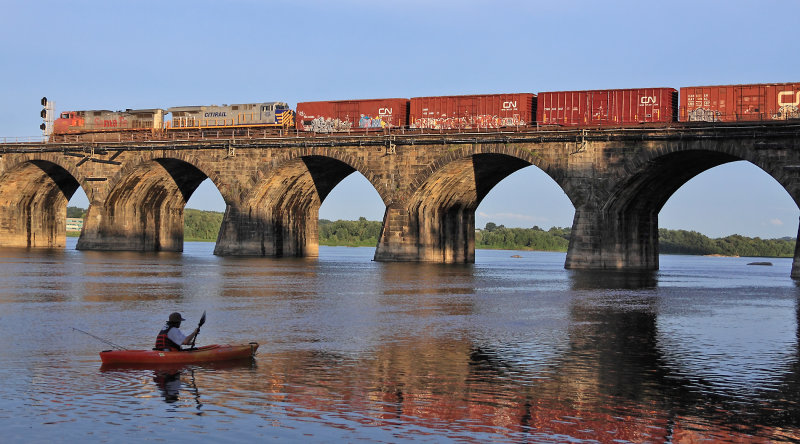 A Eastbound NS train crosses the river in the last light of the day 