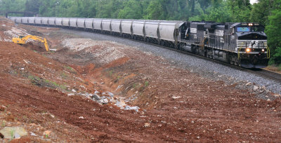 A Northbound grain train passes a crew working drainage for the new roadbed at Jones Knob road 