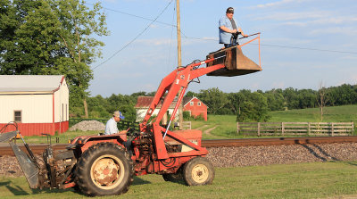My husband up in the bucket of Roberts tractor, waiting on a Heritage unit 