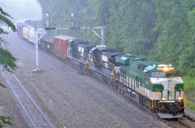 SR 8099 leads train 197 through the crossover at Revilo during a strong summer storm 