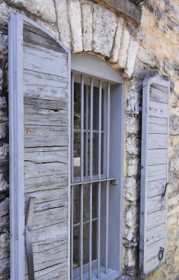 Barred windows and wooden shutters on the barrel house. 
