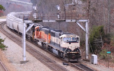 A Southbound grain train comes under the signals at Revilo KY with a set of BNSF power on a cloudy day 