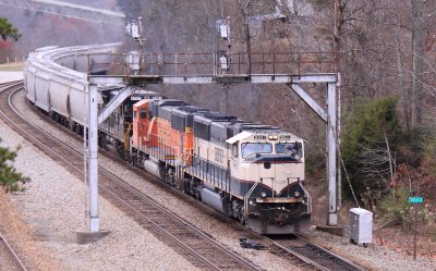 A Southbound grain train comes under the signals at Revilo KY with a set of BNSF power on a cloudy day