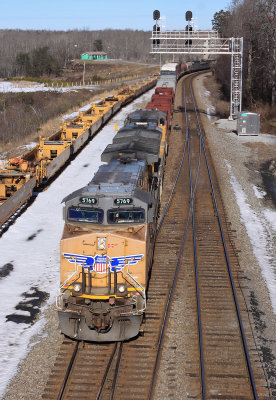 179 passes a long string of stored well cars at Revilo 