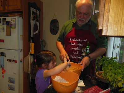 Helping grandpa add flour to bowl