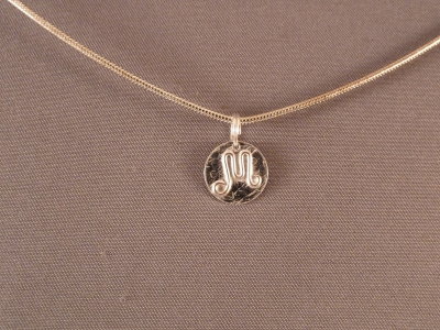 Sterling charm, about the size of a dime. Sold
