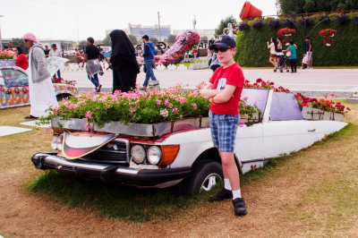 1036923 Carson Standing Next to an Old Car in Dubai Miracle Gardens