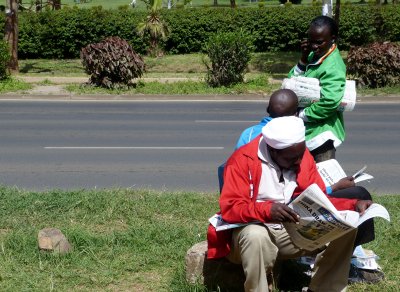 Newspaper sellers take a break to read the paper on Uhuru Highway