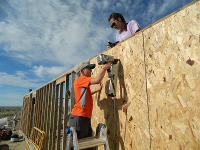 Philip handling the nail gun like a pro as Hanna looks on