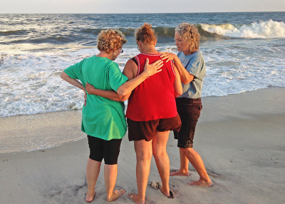 TWO OF OUR LADIES, PRAYING WITH A WOMAN THEY MET ON THE BEACH   
