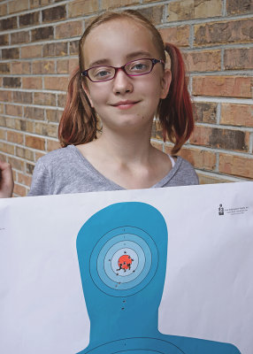 GRANDDAUGHER KATIE SHOWS OFF ONE OF HER TARGETS, AFTER A RECENT OUTING TO THE SHOOTING RANGE