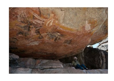 Tommo sitting under ancient Aboriginal rock art