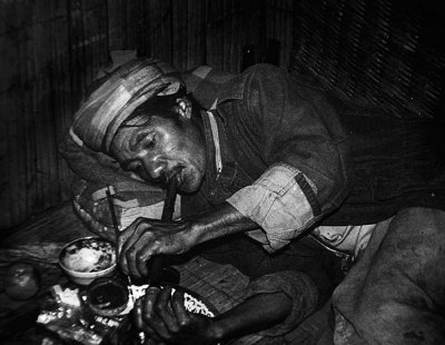 Akha tribesman smoking opium. Thailand