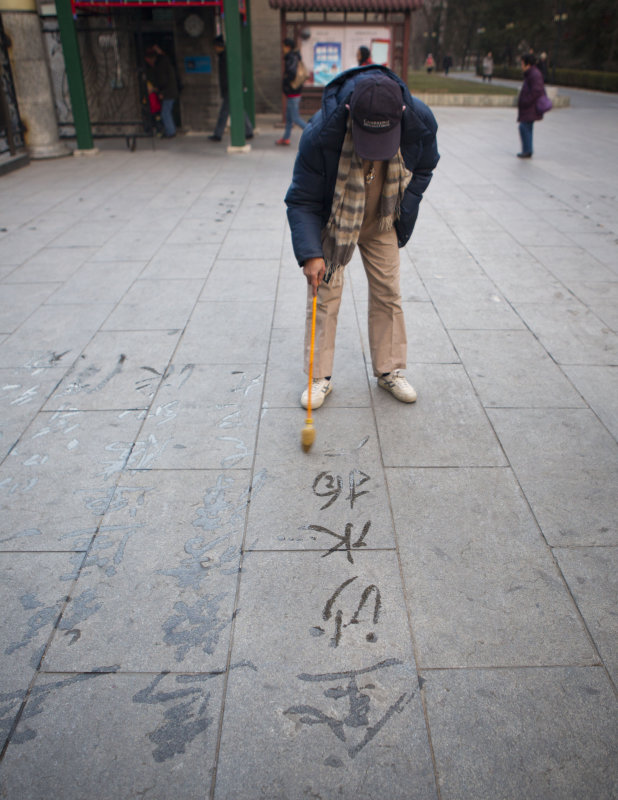 Man writing caligraphy using water 