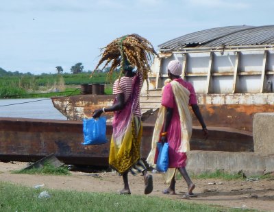 Woman carrying dried, braided  fish at Bor Harbor, South Sudan