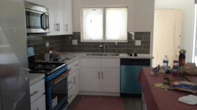 32. Looking into kitchen from dining room, grey subway tile as backsplash