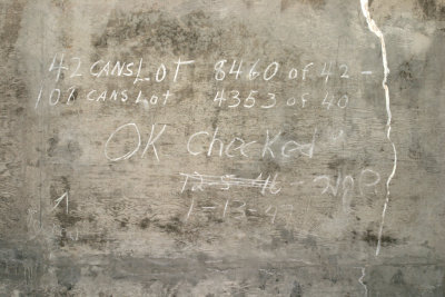 A 1947 inventory chalked on a magazine wall records 150 powder cans in storage.