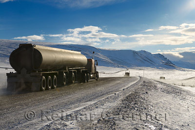 Tankers and trucks driving the Dalton Highway through the Brooks Range mountains Alaska