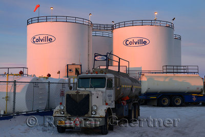 Gas tanks and tanker trucks at sunrise in Deadhorse Alaska