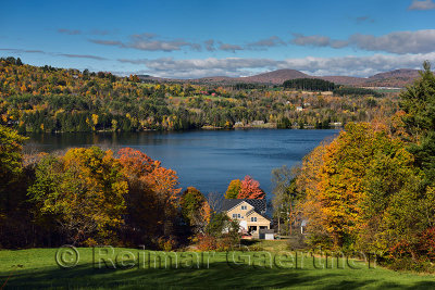 House construction on Harveys Lake West Barnet Vermont with trees in Fall color