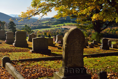 Gold maple leaves and American flags at Peacham Corner Cemetery Vermont in the Fall