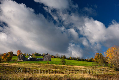 Farmhouse and barns at sunrise on hillside West Burnet Vermont in the Fall