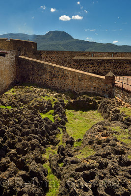 Fort San Felipe with lava rock moat and Isabel de Torres mountain Puerto Plata Dominican Republic