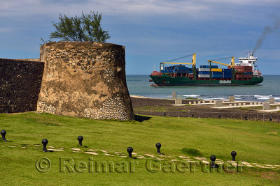 Container ship entering Puerto Plata Bay and port with walls of San Felipe fortress