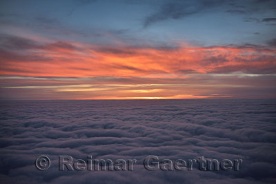 Red cloud sunrise above the clouds from a jet airplane