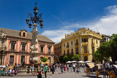 Virgen de Los Reyes Plaza with monumental fountain and Archibishops Palace with tourists