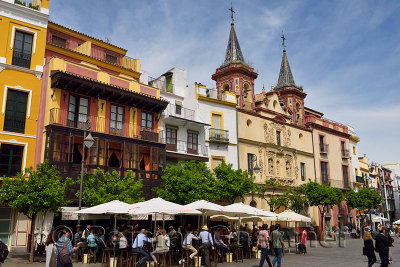 Crowds of tourists at plaza del salvador Seville Spain with twin bell towers of San Juan de Dios church