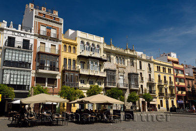 Outdoor patio with tourists and varied architectural styles in Plaza de San Francisco Seville Spain