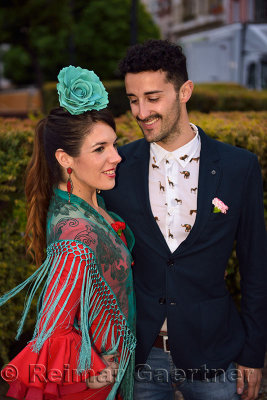 A woman in a flamenco dress with partner at dawn after a night out in Seville Andalusia