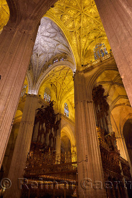 Choir area with organ pipes under lofted ceilings and stained glass windows in the Seville Cathedral