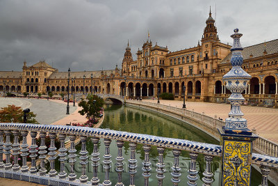Main building from a bridge with painted ceramic railing over the canal at Plaza de Espana Seville Spain