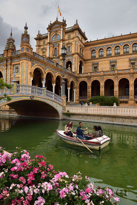 Tourists in rowboat hamming for a selfie on the canal at Plaza de Espana Seville Spain