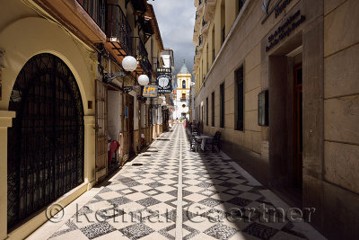 Pedro Romero street with cafe restaurants and Socorro parish church in Ronda Spain